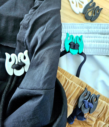 Wiggley string tie fastened to multiple types of drawstring and clothes, holding drawstrings in place, protecting clothing in the wash.