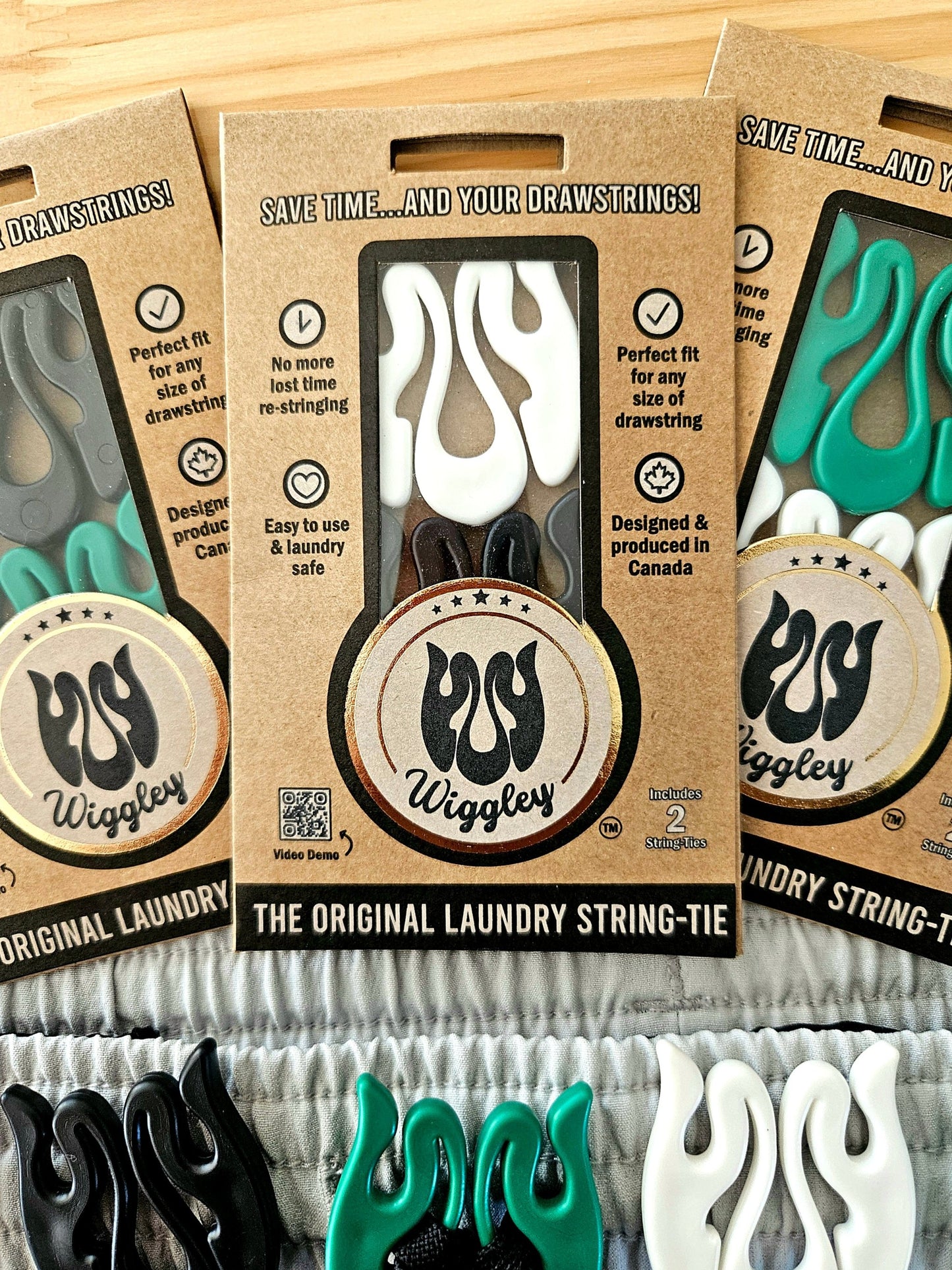 Photo of Wiggley String-Tie eco-friendly packaging, showcasing its unique shape and purpse, to secure drawstrings on clothing items in the wash and dry cycle of laundry.