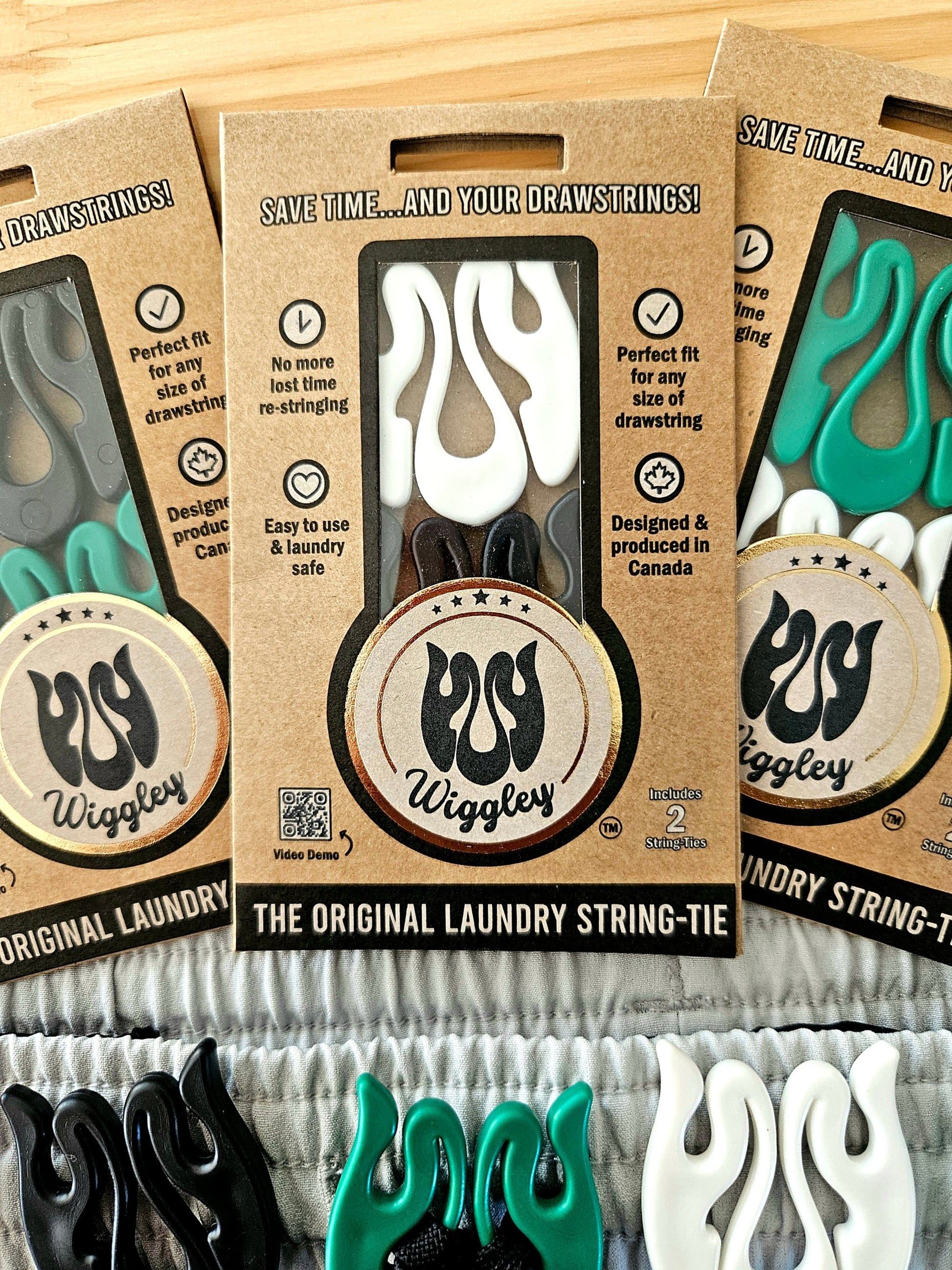 Photo of Wiggley String-Tie eco-friendly packaging, showcasing its unique shape and purpse, to secure drawstrings on clothing items in the wash and dry cycle of laundry.